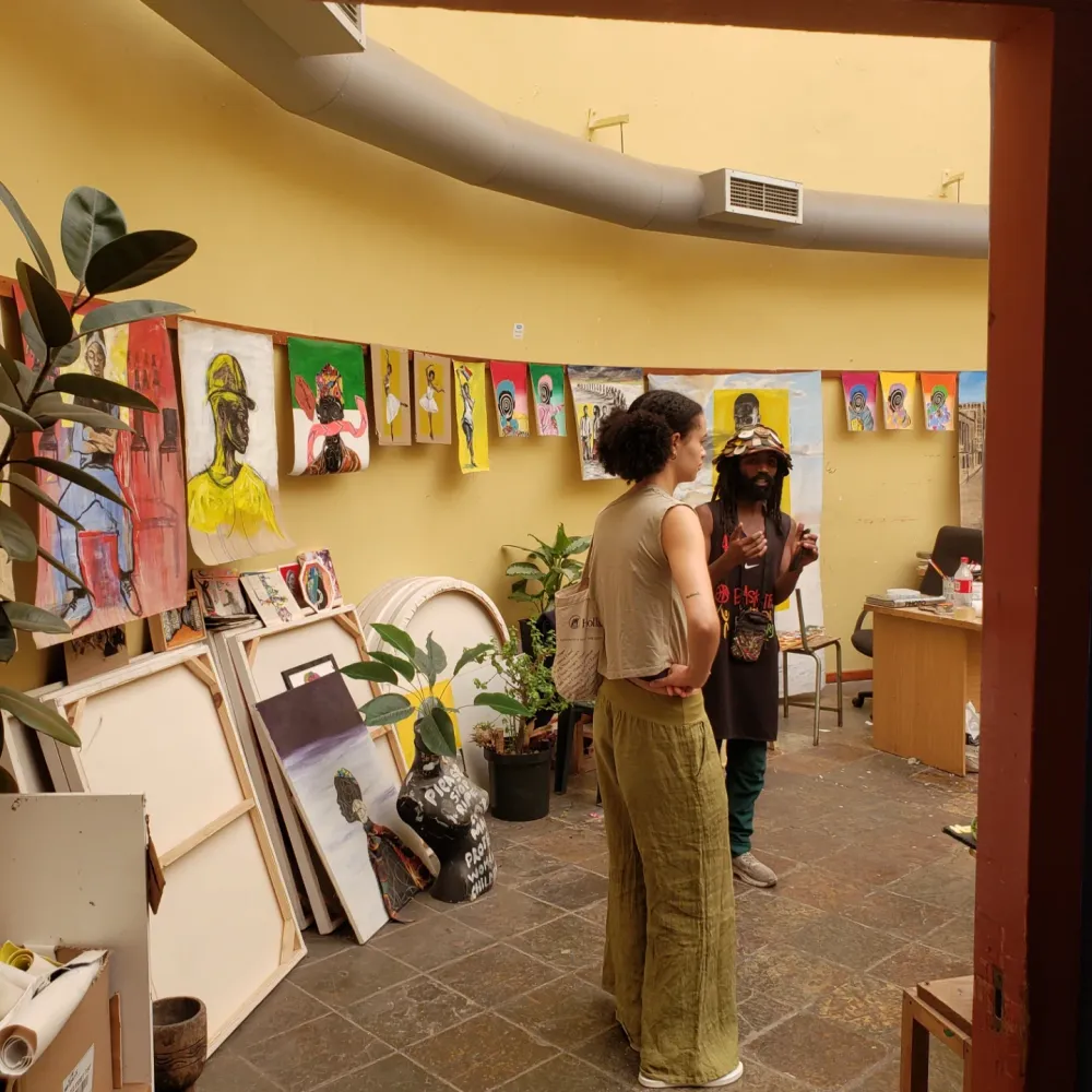 Masande explaining artworks in the studio