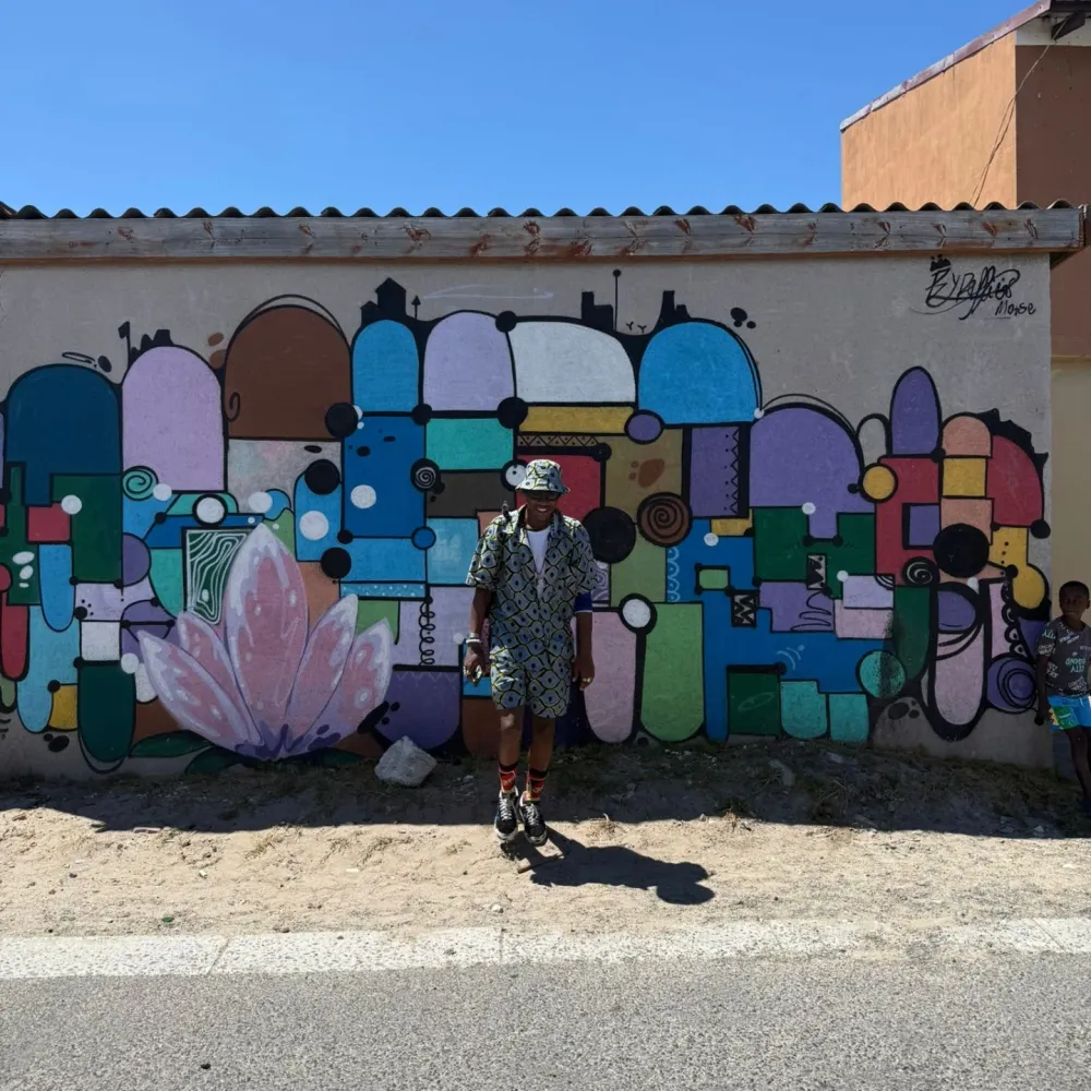 Masande in front of a street art mural
