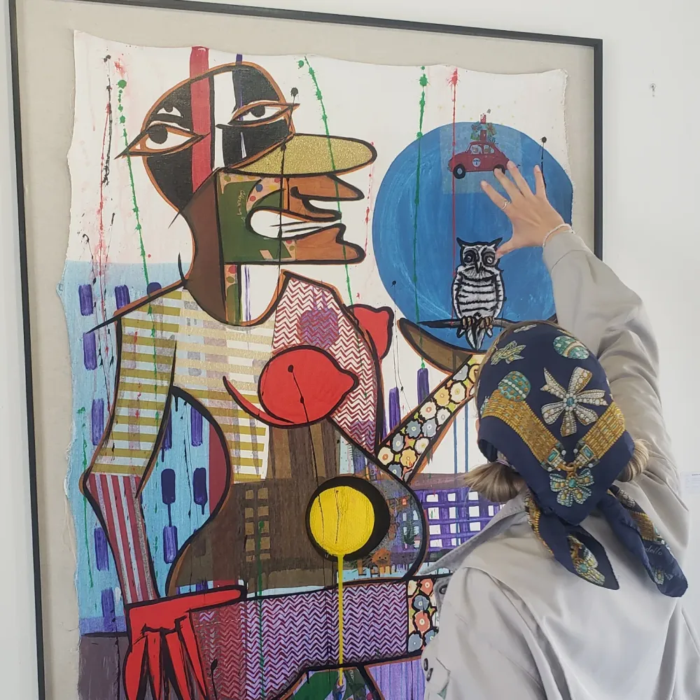 Visitor looking at a framed painting in the gallery